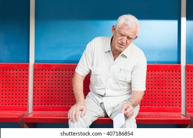 Man sitting on bench at bus stop
