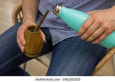 A Man Sitting On A Chair Holds A Traditional Yerba Mate Vessel In His Hand, Paraguay Holly Herbal Infusion Popular In South America 