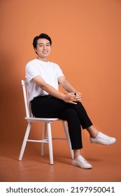 man sitting on chair  isolated on orange background - Shutterstock ID 2197950041