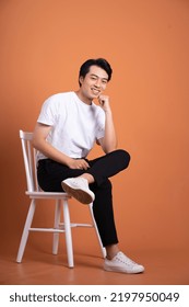 man sitting on chair  isolated on orange background - Shutterstock ID 2197950049