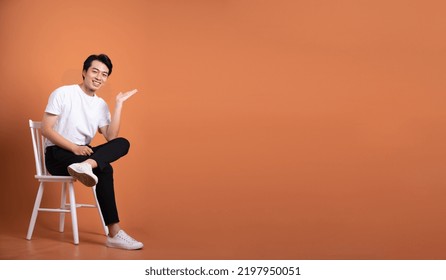 Man Sitting On Chair  Isolated On Orange Background