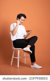 man sitting on chair  isolated on orange background - Shutterstock ID 2197950053