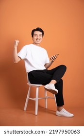 man sitting on chair  isolated on orange background - Shutterstock ID 2197950063