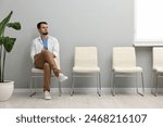 Man sitting on chair and waiting for appointment indoors