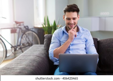 Man Sitting On Couch With Laptop
