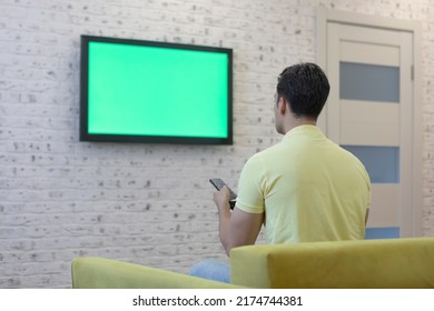 Man Sitting On The Couch And Watching Tv. Green Screen Concept