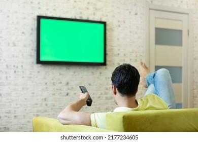 Man Sitting On The Couch And Watching Tv. Green Screen Concept