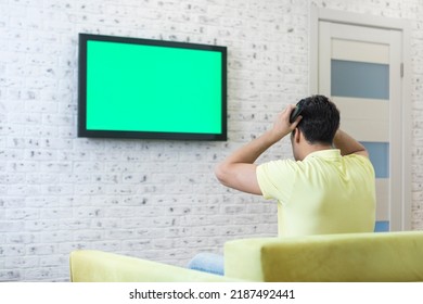 Man Sitting On The Couch And Watching Tv. Green Screen Concept	