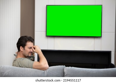 Man Sitting On The Couch And Watching Tv. Green Screen Concept	