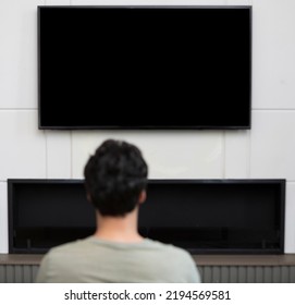 Man Sitting On The Couch And Watching Tv. Black Screen Concept	