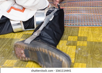 
Man Sitting On The Floor With Old Polio Knee Caliper Brace.
