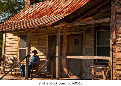 Man Sitting on Homestead Porch - Powered by Shutterstock