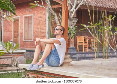 Man Sitting On A House Patio / Porch And Enjoying Summertime.