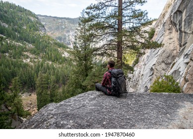 Man Sitting On Ledge On John Muir Trail In Yosemite National Park