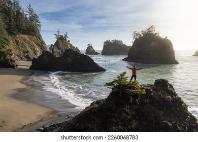 Man sitting on a rock enjoying the amazing view of the sea and sea stacks in this beautiful spot on the Oregon coast - Powered by Shutterstock