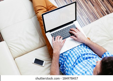 Man Sitting On A Sofa And Browsing The Web