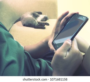 Man Sitting On Sofa Using Mobile Phone 