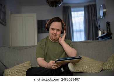 Man sitting on sofa and using digital tablet