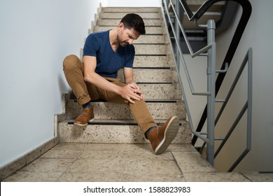 Man Sitting On Staircase After Slip And Fall Accident