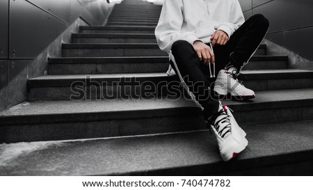 man is sitting on the stairs. Lifestyle photography. Urban wallpaper. Interior poster. Look book. Hype sneakers. Best

