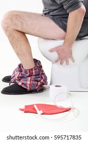 Man Sitting On A Toilet With Enema Bag