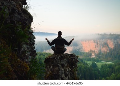 Man Sitting On The Top Of The Mountain In Yoga Pose