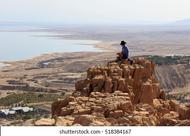 Man Is Sitting On Top Of Mountain And Enjoying The Dead Sea Landscape. Israel 