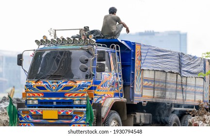 The Man Was Sitting On Top Of The Truck To Watch The Site Work Under Construction Behind The Truck.