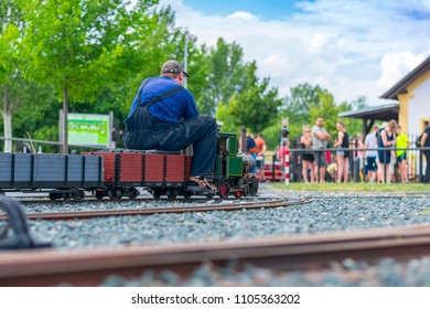 Man Sitting On Train Model. Mini Train Station. Old Man Doing His Hobby. Train Model. 