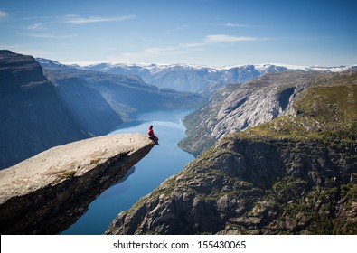 man sitting on trolltunga in norway  - Powered by Shutterstock