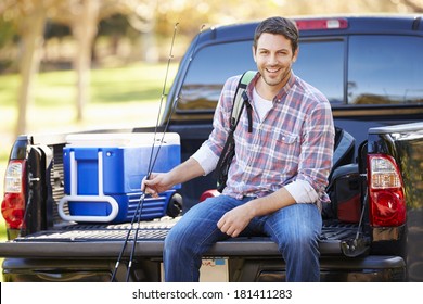 Man Sitting In Pick Up Truck On Camping Holiday