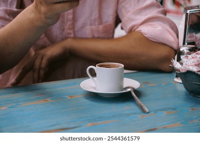 a man is sitting at a table and drinking coffee from a cup. Breakfast at the coffee shop