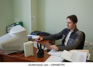 Man sitting at the table with old computer and doing his job