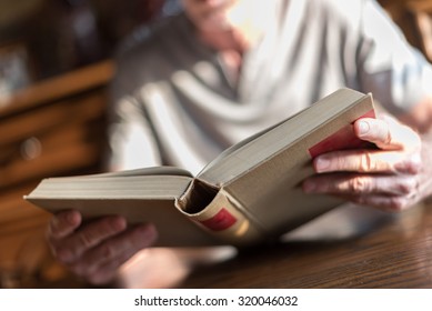Man sitting at a table reading a book