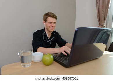Man sitting at table using laptop computer