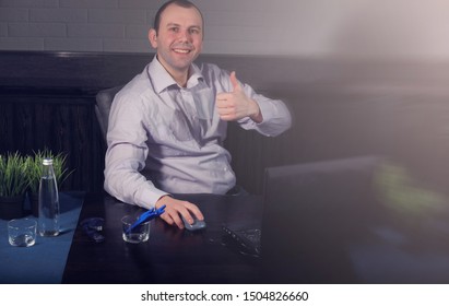 man sitting at table and working on laptop
