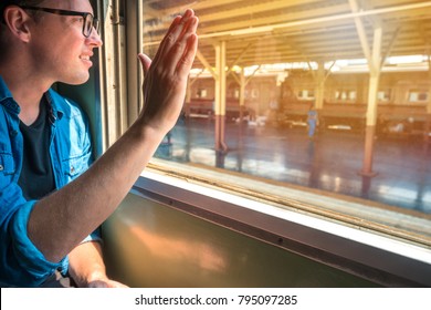 Man Sitting In A Train Raise His Hand To Say Hello Or Goodbye