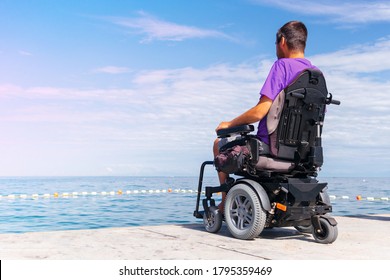 Man sitting in a wheelchair looking at sea. Head and spine injury. Dangers of jumping into water from heights.
