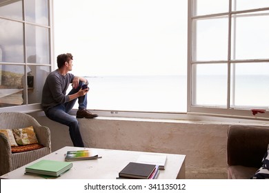 Man Sitting At Window And Looking At Beautiful Beach View - Powered by Shutterstock