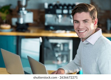 Man sitting at wooden table in café workspace working on laptops amid coffee equipment, copy space. Coffeelover, remote working, moderncafeteria, minimalisticdesign, daytime, professional,