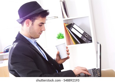 Man sitting working at the office with the computer having a coffee