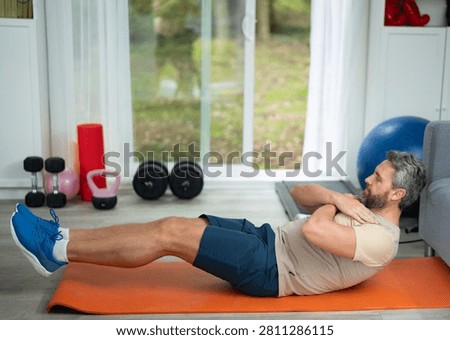 Man with six pack abs during a morning home workout. Fit sportsman exercising his abdominal six pack abs muscles. Man training six pack abs. Man doing abdominal exercises for flat stomach six pack.