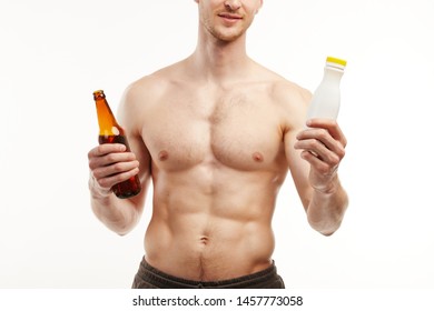 Man With A Six Pack Holds Beer Bottle In One Hand And Dairy Bottle In The Other.