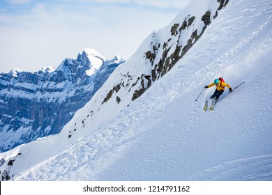 A Man Is Skiing Down The Hill On The Steep Slope In Alps. Chamonix. High Mountain Area.