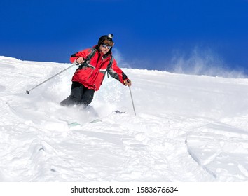 A man is  skiing on a mountainside  in a beautiful sunny day.
