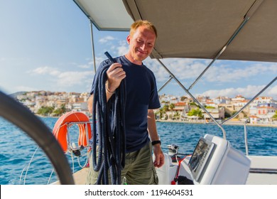 Man Skipper At His Sail Boat, Controls Ship In The Sea Yacht Race. Luxery Vacations, Sailing, Adventure, Travel.