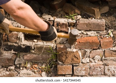 Man With Sledgehammer Destroying Brick Wall