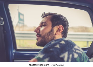 Man Sleeping In The Backseat Of A Car On A Trip