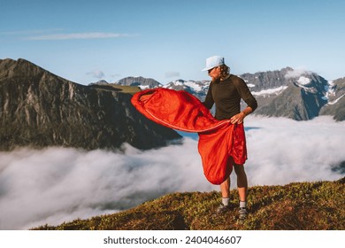 Man with sleeping bag camping gear hiking in mountains, adventure travel lifestyle active vacations tour outdoor, traveler exploring Norway survival in wilderness - Powered by Shutterstock