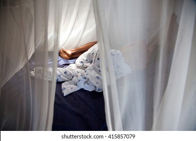 Man Sleeping Behind Mosquito Net